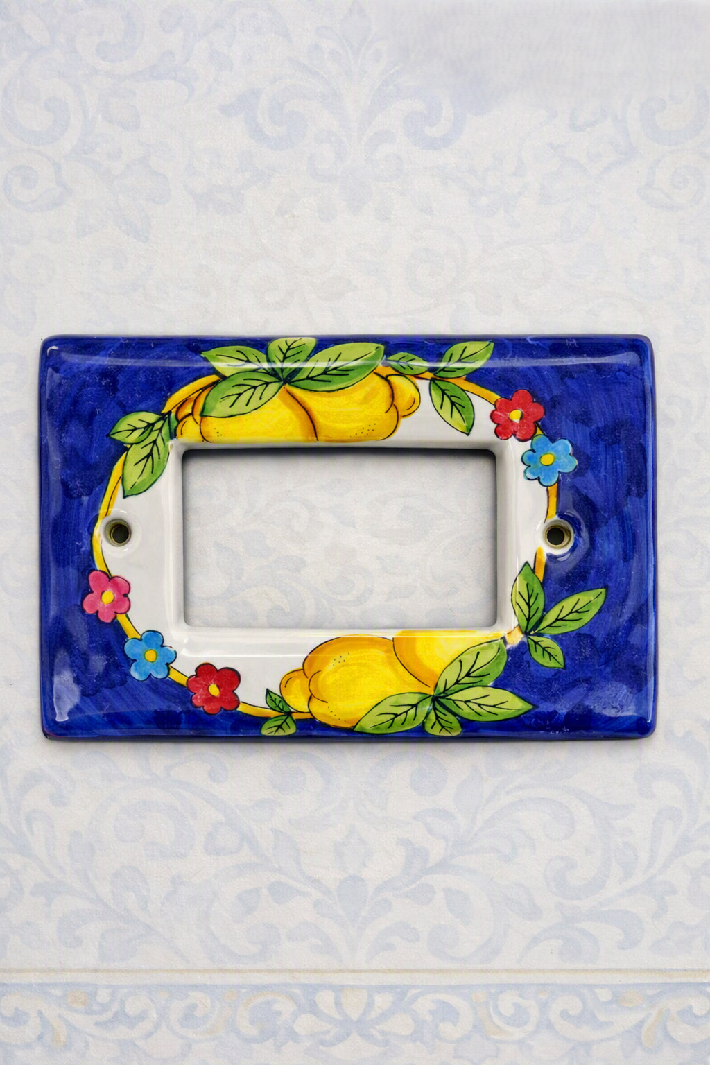 Placca copri interruttore in ceramica modello Matix decorata a mano, con decoro artigianale ispirato ai colori e ai motivi della Costiera Amalfitana.
